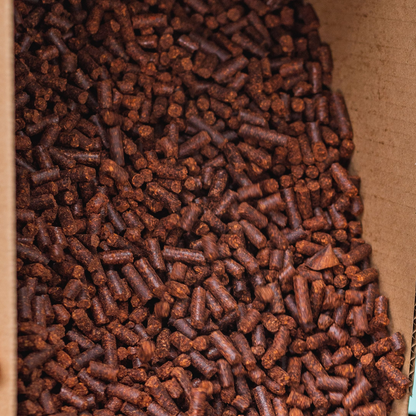 A 2 lb bag of Smokin' Pecan Shell Pellets contains small brown cylindrical pellets packed together.