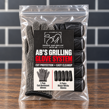 A sealed package of AB’s Grilling Glove System from Smokin and Grillin wit AB rests on a wooden surface, featuring one pair of cut-resistant gloves and five pairs of black nitrile gloves inside, with product details and branding for the grilling glove system clearly visible.